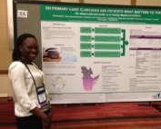 A smiling Black woman standing next to a research poster